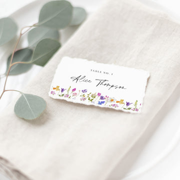 a place setting with a place card on a napkin